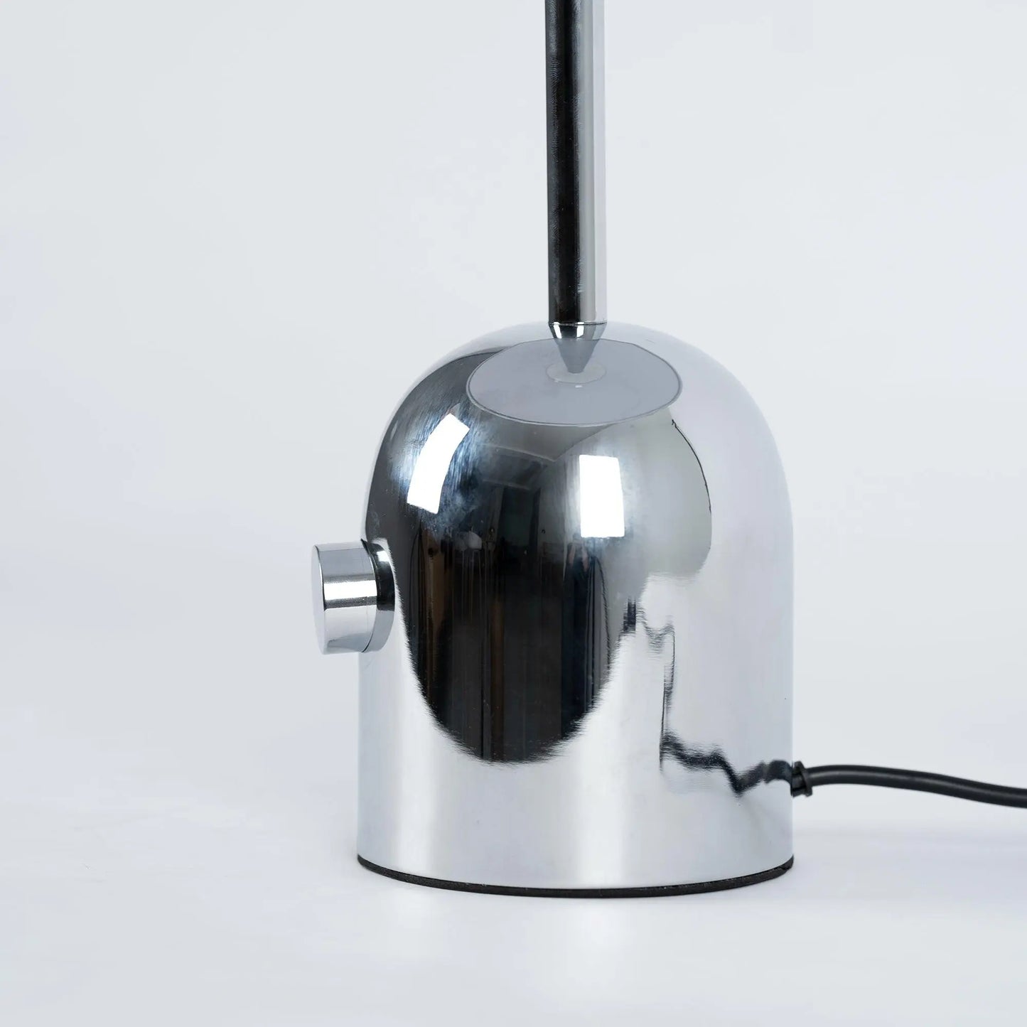 Close-up of BellaGlow table lamp in chrome finish, emphasizing the lamp’s refined design and smooth texture- base.