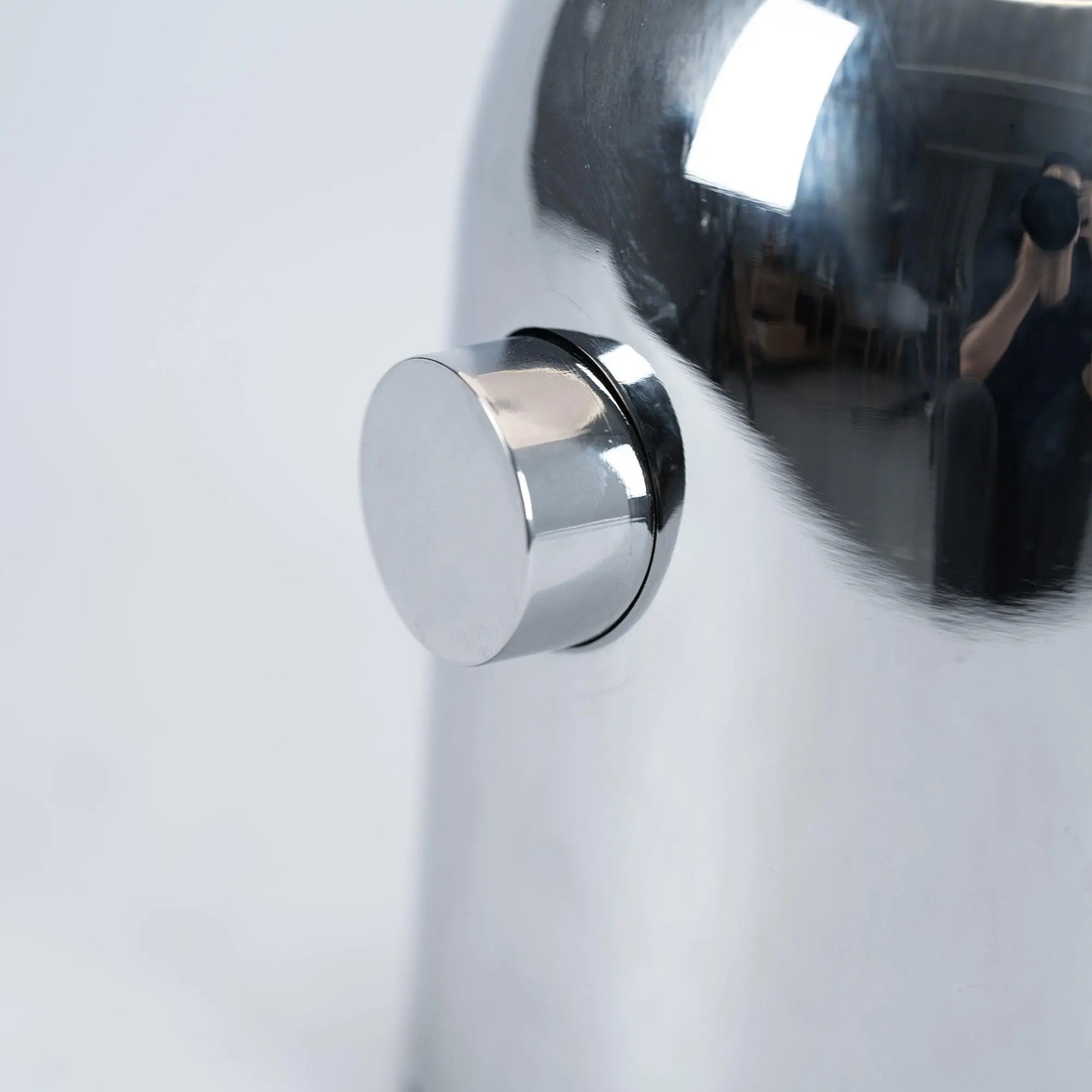 Close-up of BellaGlow table lamp in chrome finish, emphasizing the lamp’s refined design and smooth texture - button.