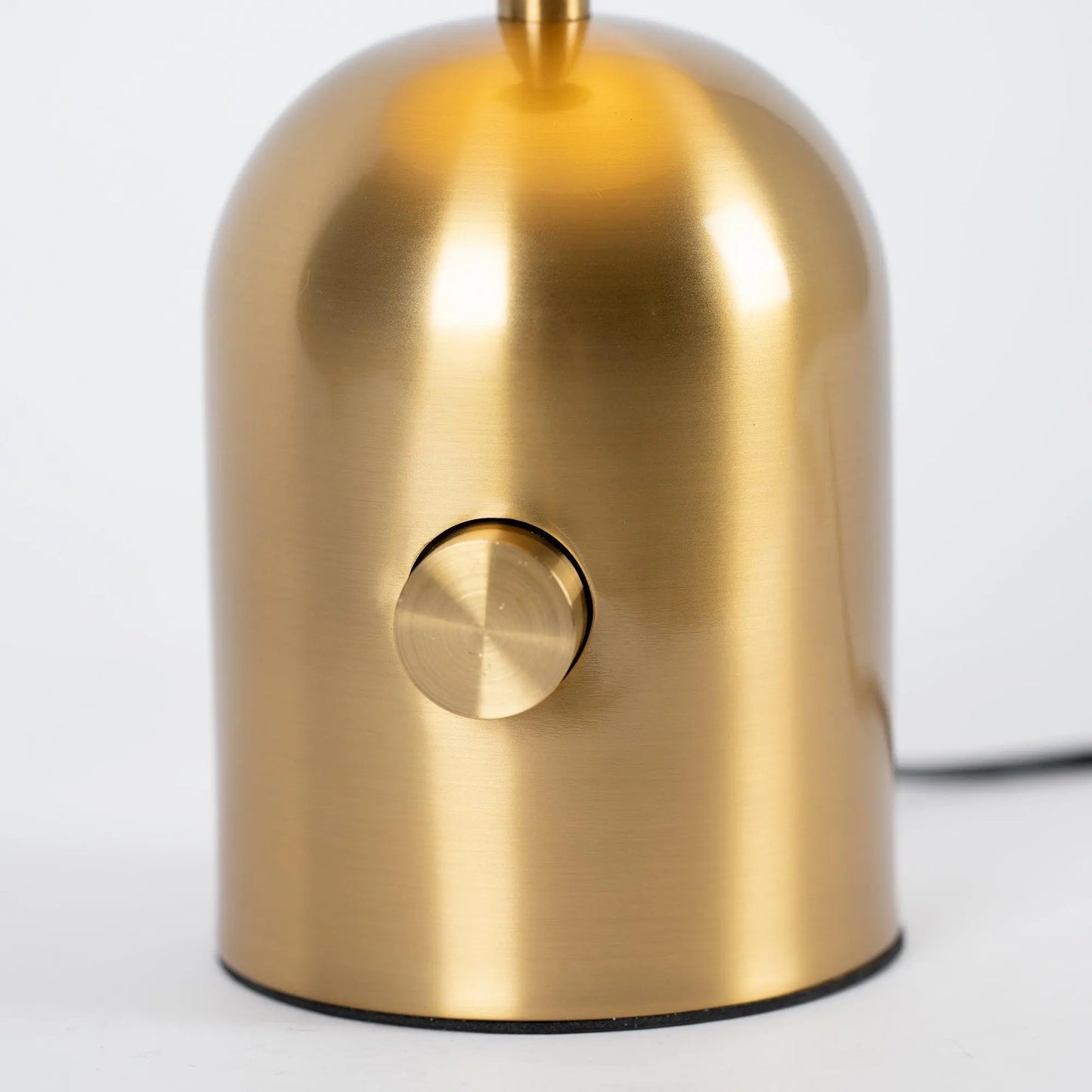 Close-up of BellaGlow table lamp in gold finish, emphasizing the lamp’s refined design and smooth texture - button.