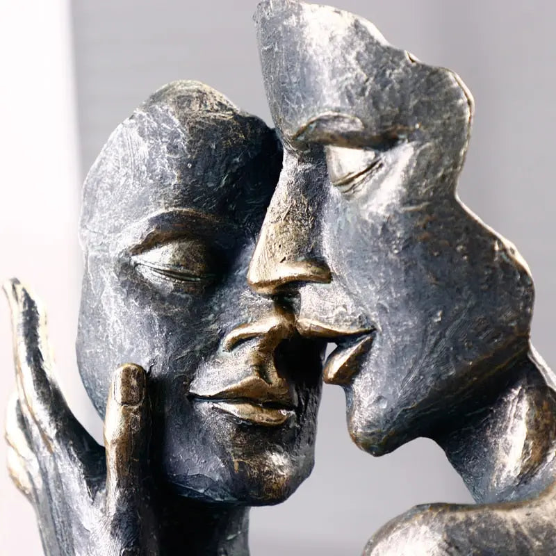 Close-up view of the EmbraceArt sculpture, highlighting the soft black and bronze tones of the resin material.