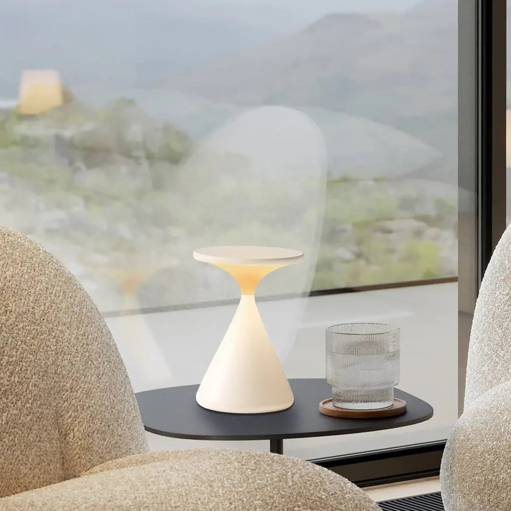 GlowSphere cordless hourglass lamp placed in a modern decor setting, complementing contemporary furniture with its sleek design.

