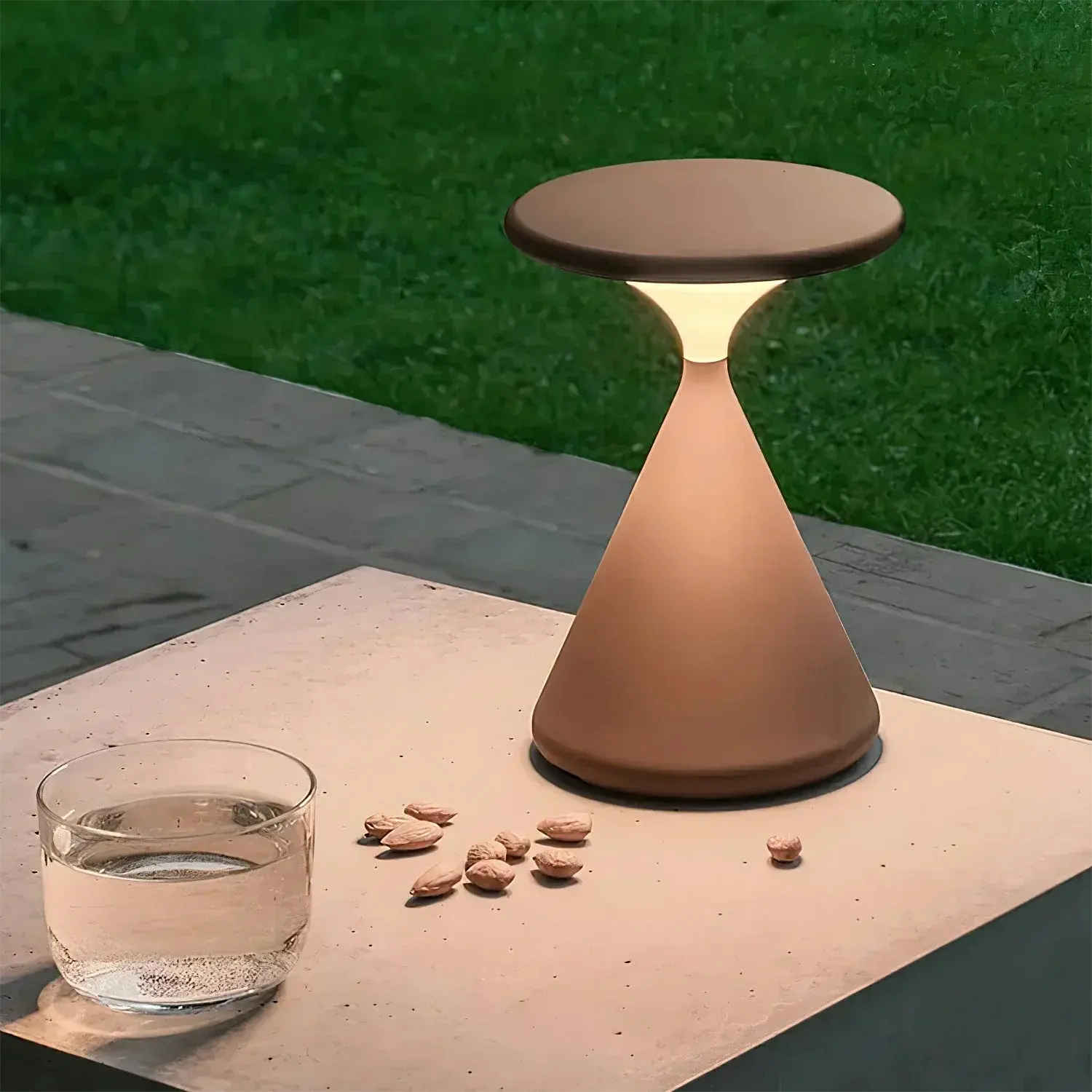 GlowSphere cordless hourglass lamp used outdoors, showcasing its portability for creating ambient lighting in patios or garden spaces.