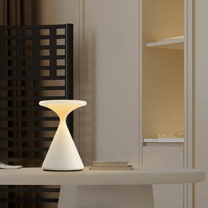 GlowSphere hourglass lamp casting a soft, warm glow, ideal for creating ambient lighting in a living room or bedroom.